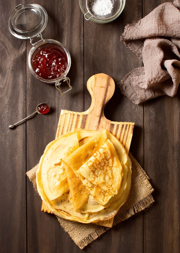 Photo crêpes disposées sur une planche de bois